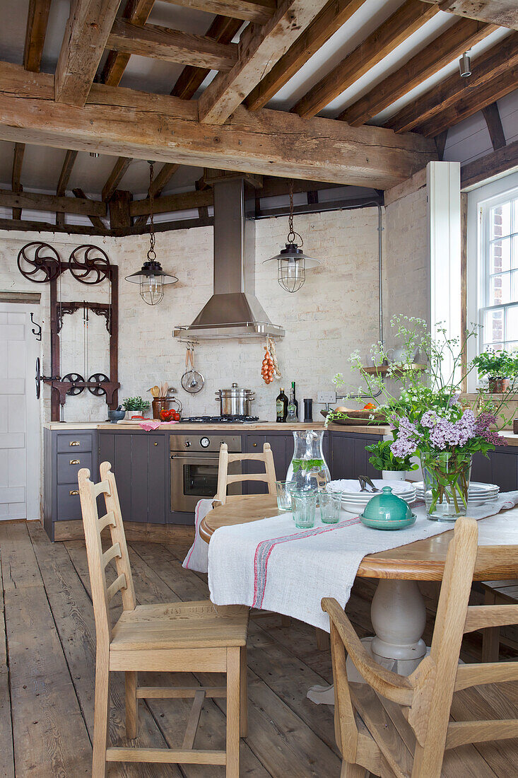 Tisch und Stühle im Stil des Kunsthandwerks in der offenen Küche einer denkmalgeschützten Windmühle (Kent, UK)