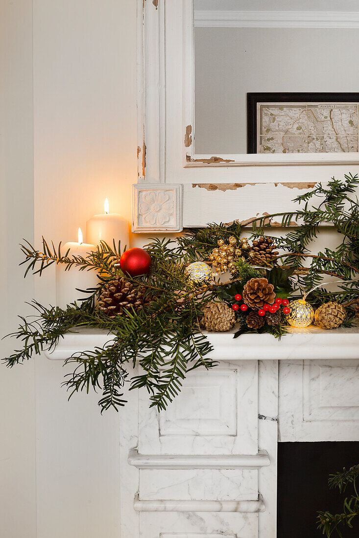 Beleuchtete Kerzen mit Weihnachtsgirlande auf dem Kaminsims im Pfarrhaus von Warehorne, Kent, UK