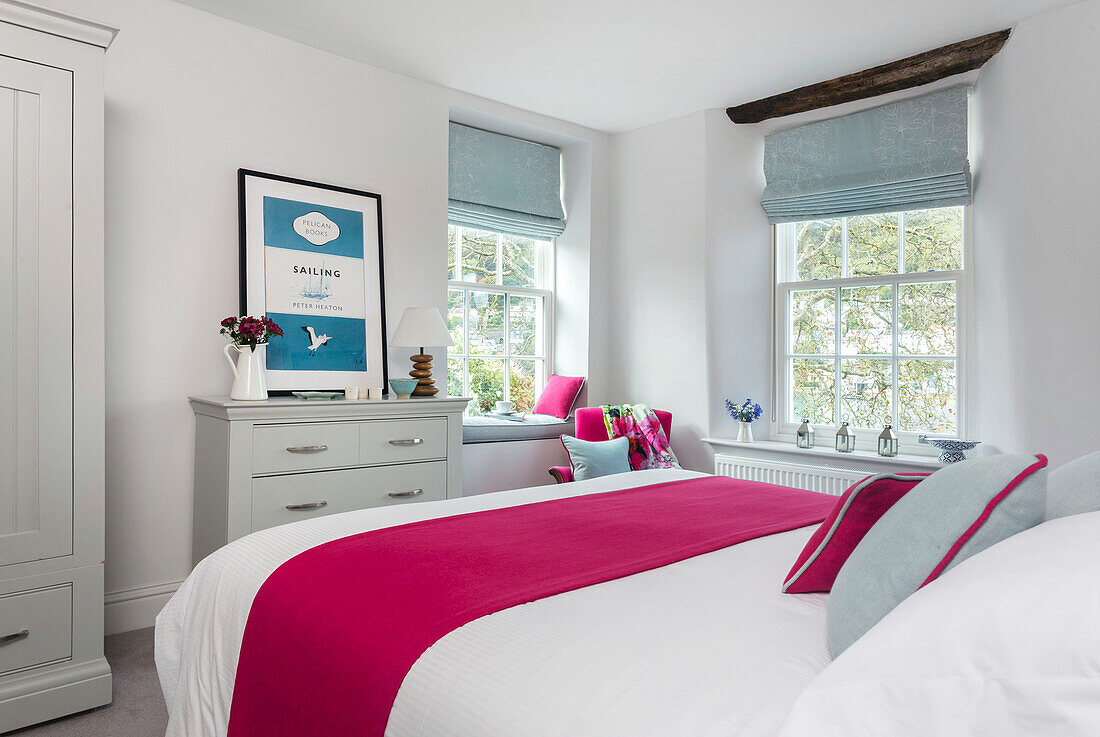 PInk runner on double bed with light blue roman blinds at window in Dartmouth Devon UK