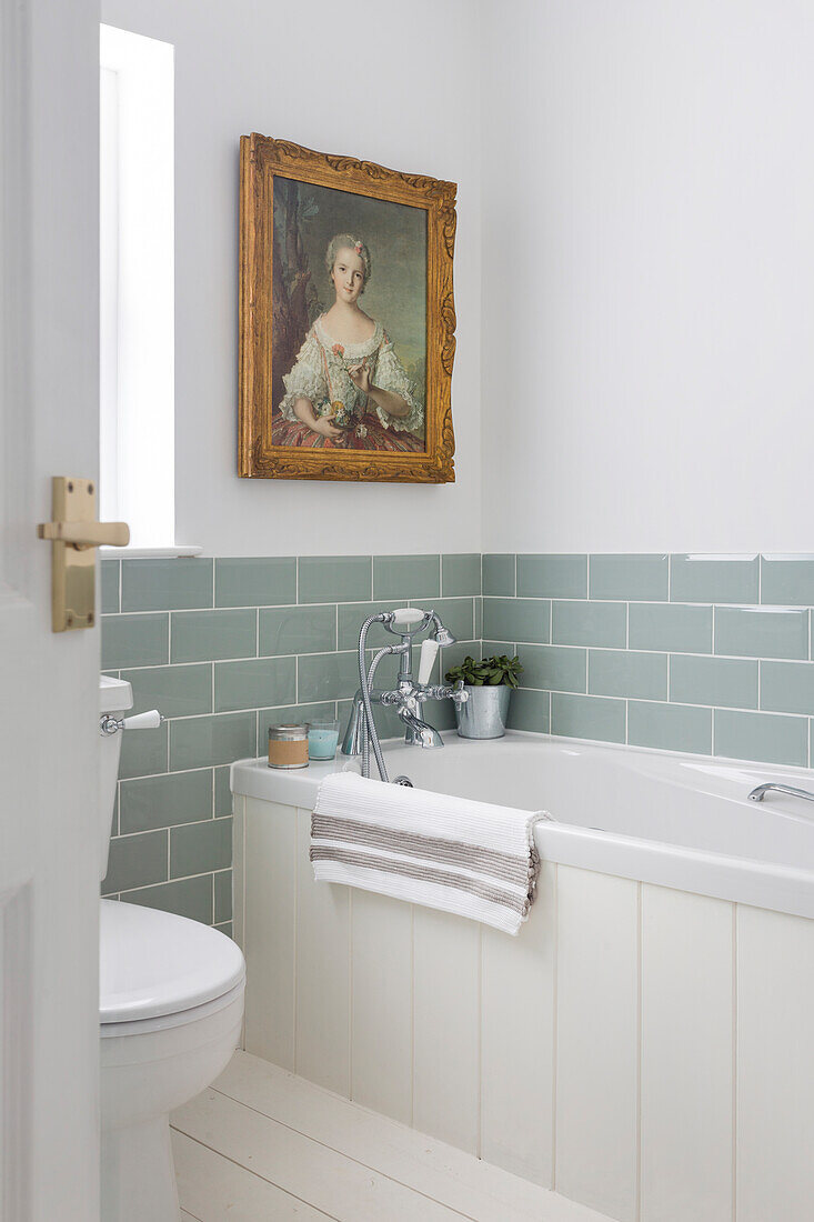 Antique portrait with sage green metro tiles in bathroom Southsea UK