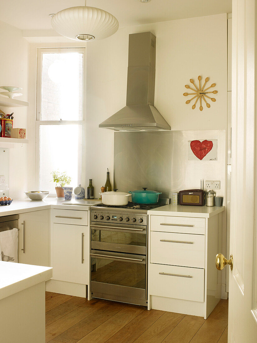 Auflaufform auf dem Kochfeld eines Edelstahlofens mit Dunstabzugshaube in der Küche eines Hauses in London England UK