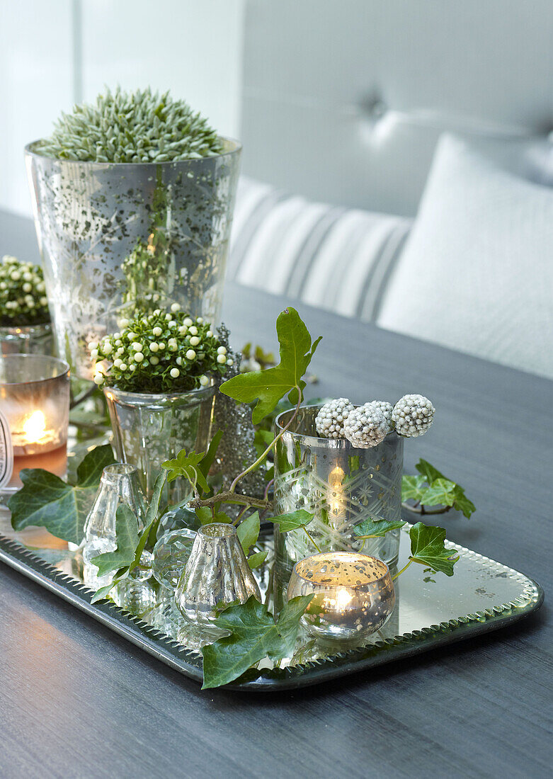 Lit candles and cut flowers on tray in London home England UK