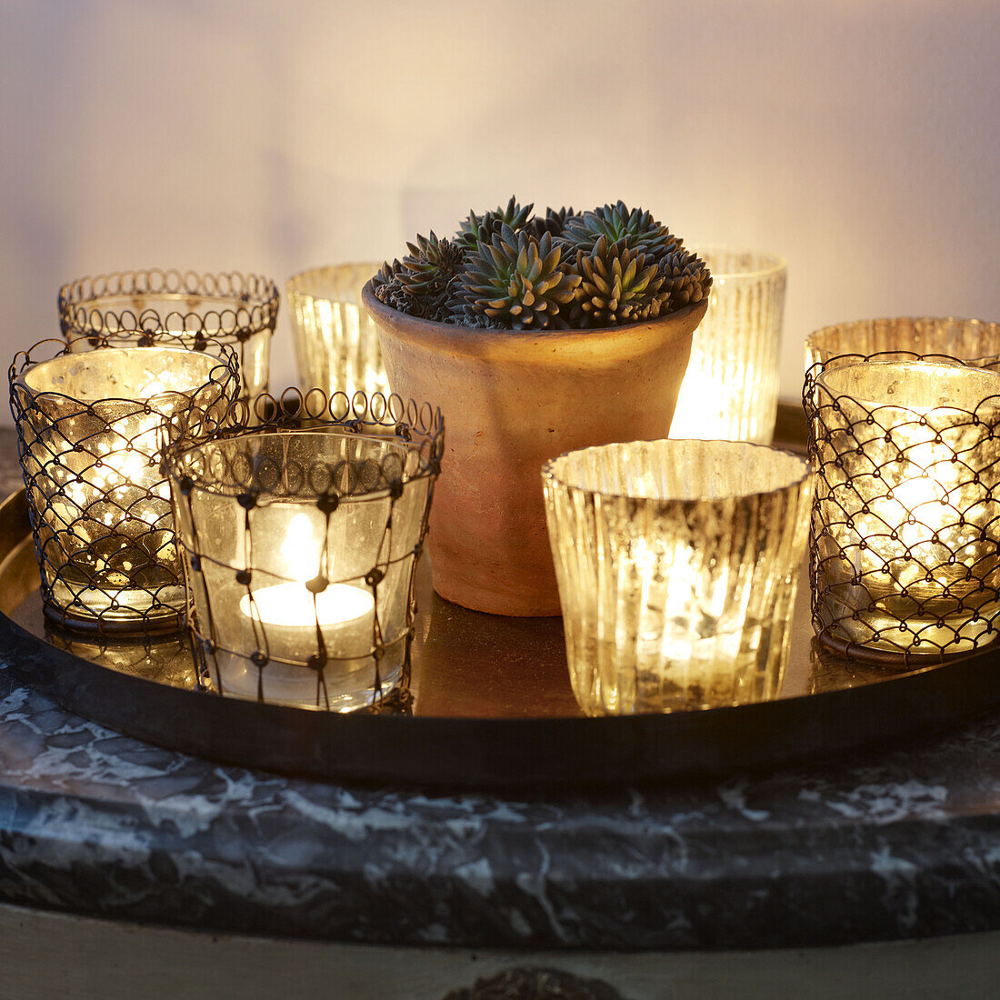 Beleuchtete Kerzen und eine Topfpflanze auf einem runden Tablett in einem Londoner Haus England UK