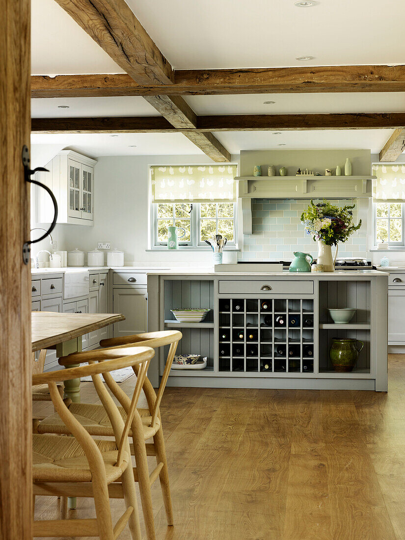Barhocker aus Holz in einer Fachwerkküche mit Weinlager in einer Bauernhausküche in West Sussex, England, Vereinigtes Königreich