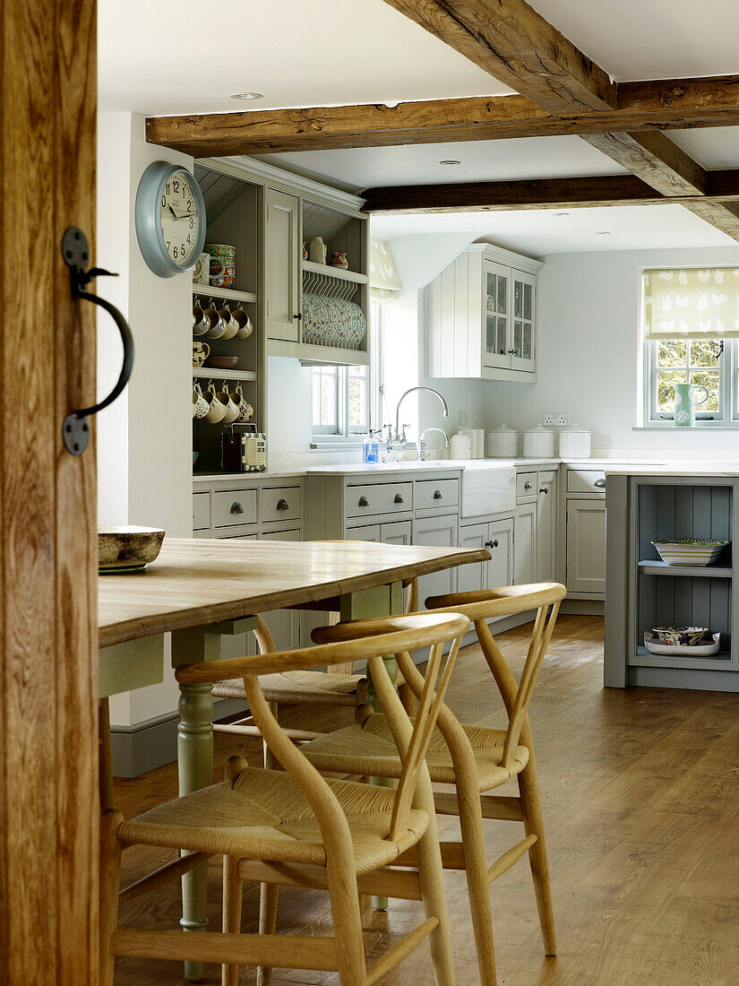 Holzstühle am Tisch mit Kommode in einer Bauernhausküche in West Sussex, England, Vereinigtes Königreich