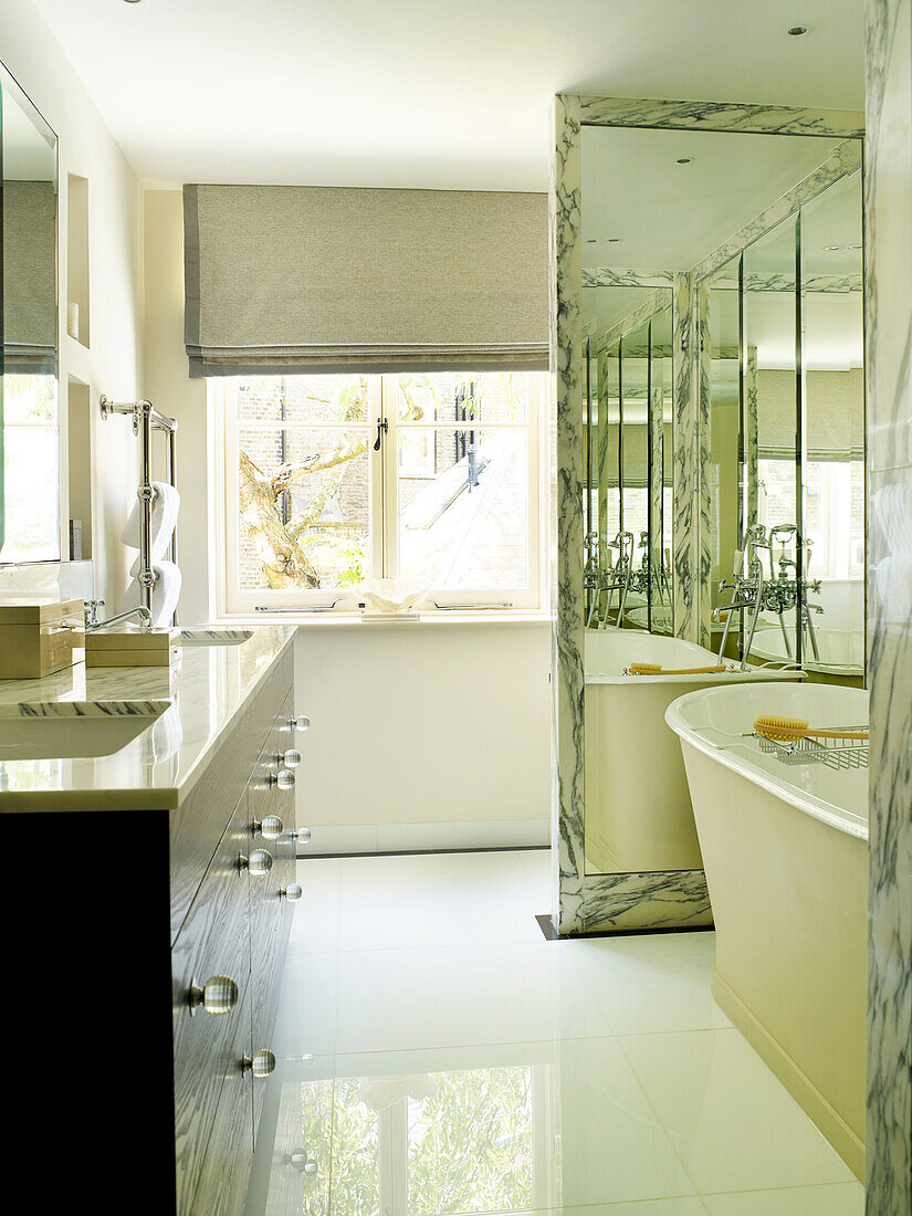 Double basins with freestanding bath in mirrored recess of London townhouse, UK