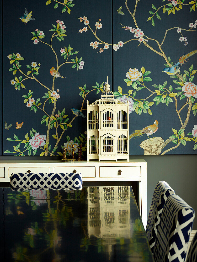 Orientalisches Paneel mit Vogelkäfig, das sich auf einem polierten Esstisch spiegelt, Wohnung in einem Londoner Stadthaus, Vereinigtes Königreich