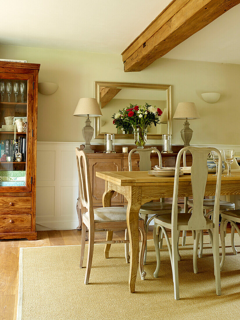 Esszimmer mit Deckenbalken über Tisch und Anrichte in einem Landhaus in Oxfordshire, England, UK