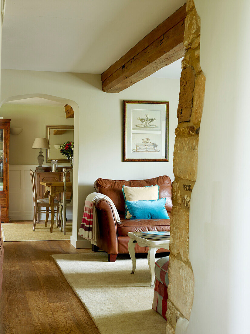 Blick vom Wohnzimmer durch einen offenen Bogen in einem modernisierten Cottage in Oxfordshire, England, UK