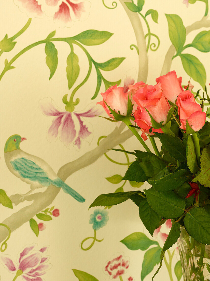 Cut roses with floral wallpaper in Oxfordshire cottage, England, UK
