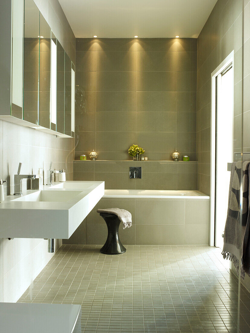 Spiegelschränke über Doppelwaschbecken in gefliestem Badezimmer eines Londoner Hauses, UK