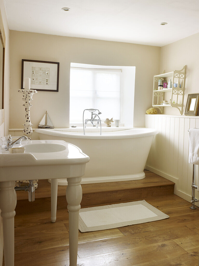 White freestanding bath at window in split-level bathroom of Nottinghamshire home England UK