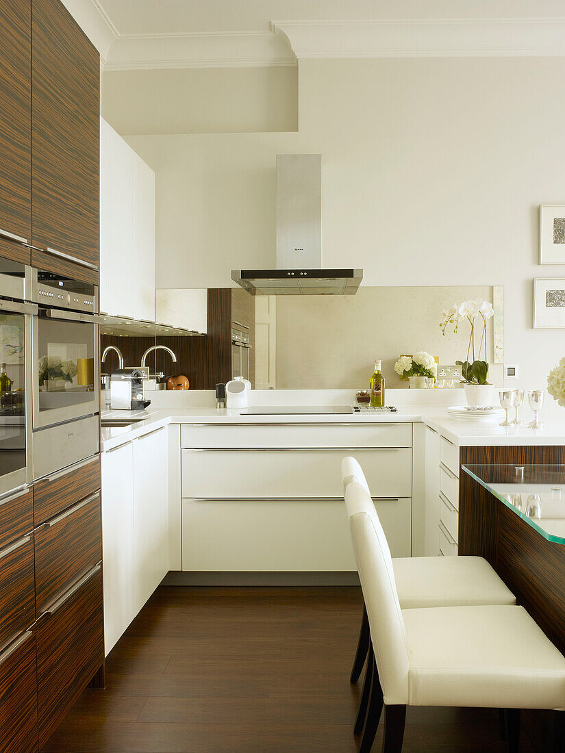 Weiße Ledersessel mit integrierten Öfen in der Küche des Stadthauses Little Venice London England UK