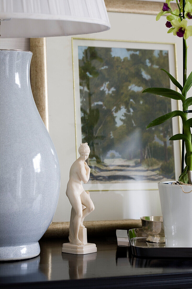 Weiße Lampe und Figur mit Orchidee und Kunstwerk in einem Londoner Haus UK