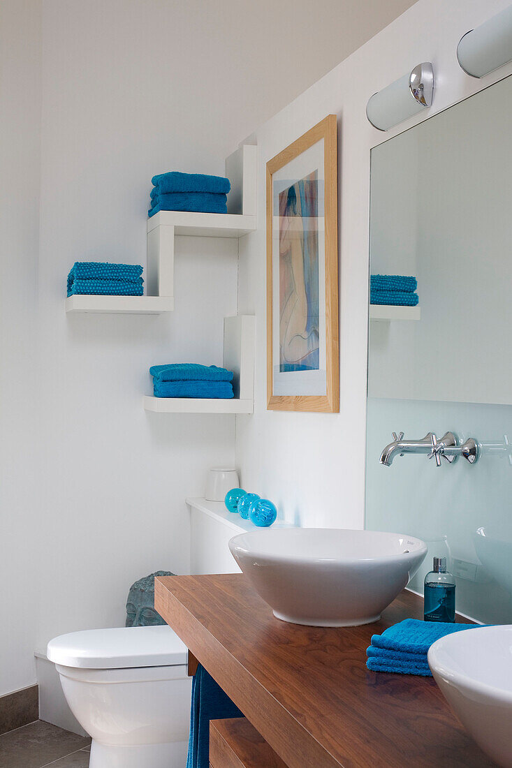 Turquoise towels on wall shelving in Cambridgeshire bathroom UK