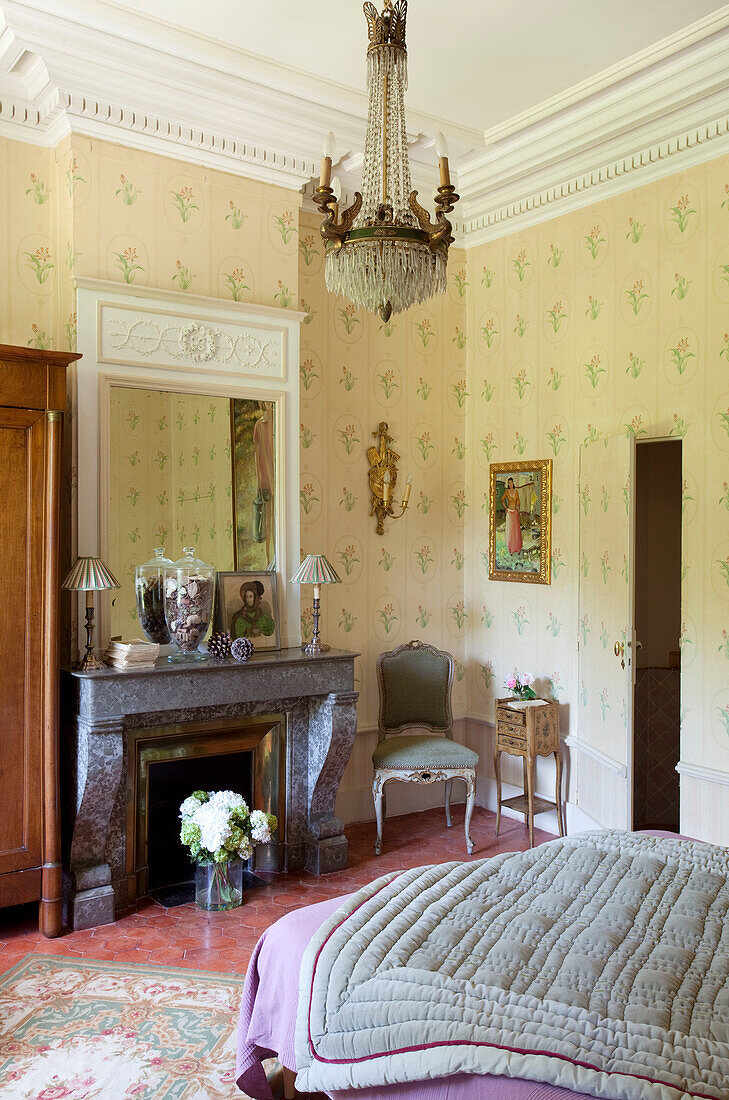 Spiegel über grauem Marmorkamin im Schlafzimmer eines französischen Chateau Gard aus dem 13