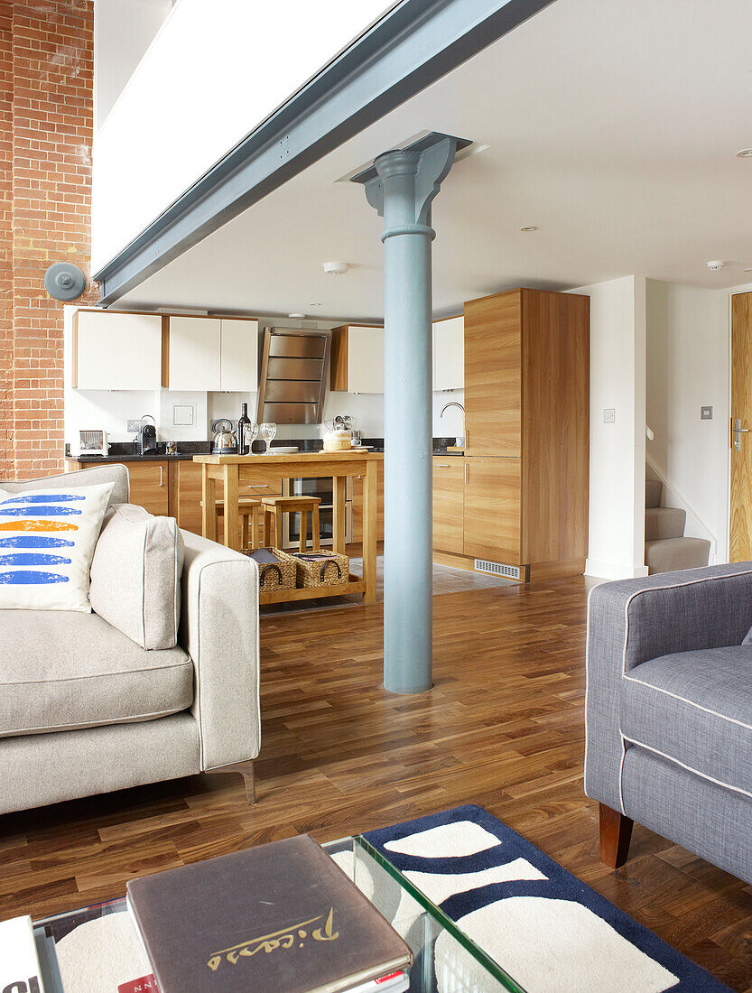Struktureller Balken in einem offenen Wohnzimmer mit doppelter Höhe in einem umgebauten Lagerhaus in Ipswich, Suffolk, England, UK
