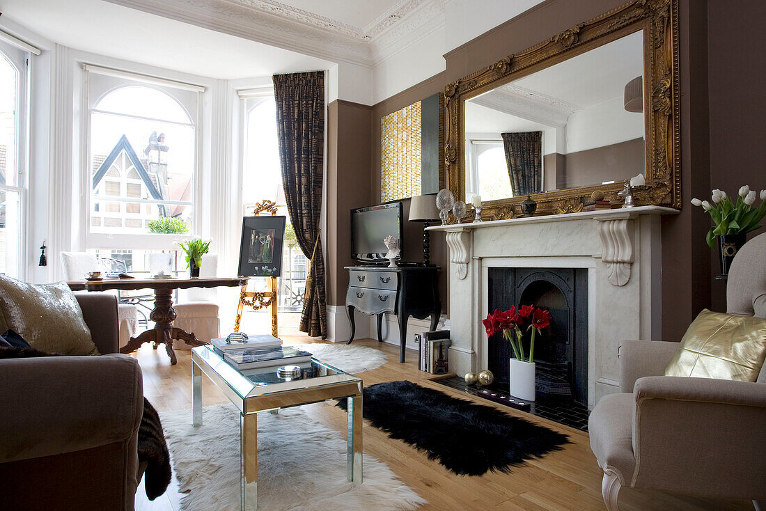 Sunlit living room with oversized gilt mirror on fireplace in Hove home East Sussex UK