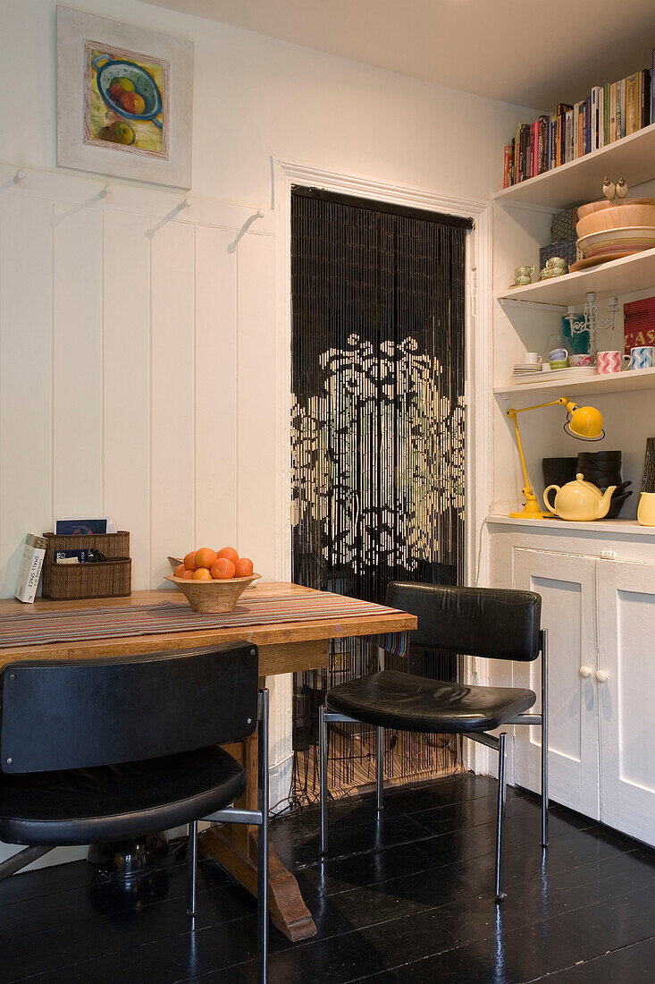 Schwarze Lederstühle am Tisch in der Küche eines Hauses in London UK