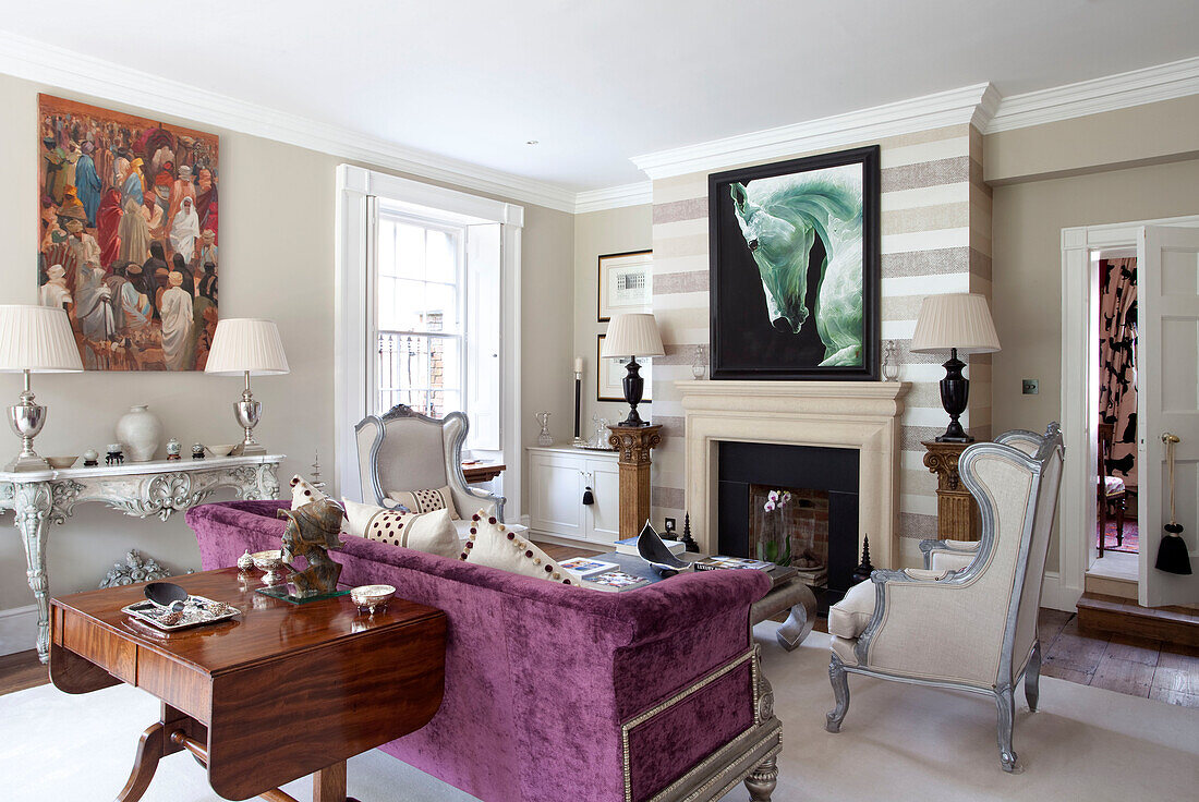 Wohnzimmer mit lilafarbenem Sofa und Kunstwerken