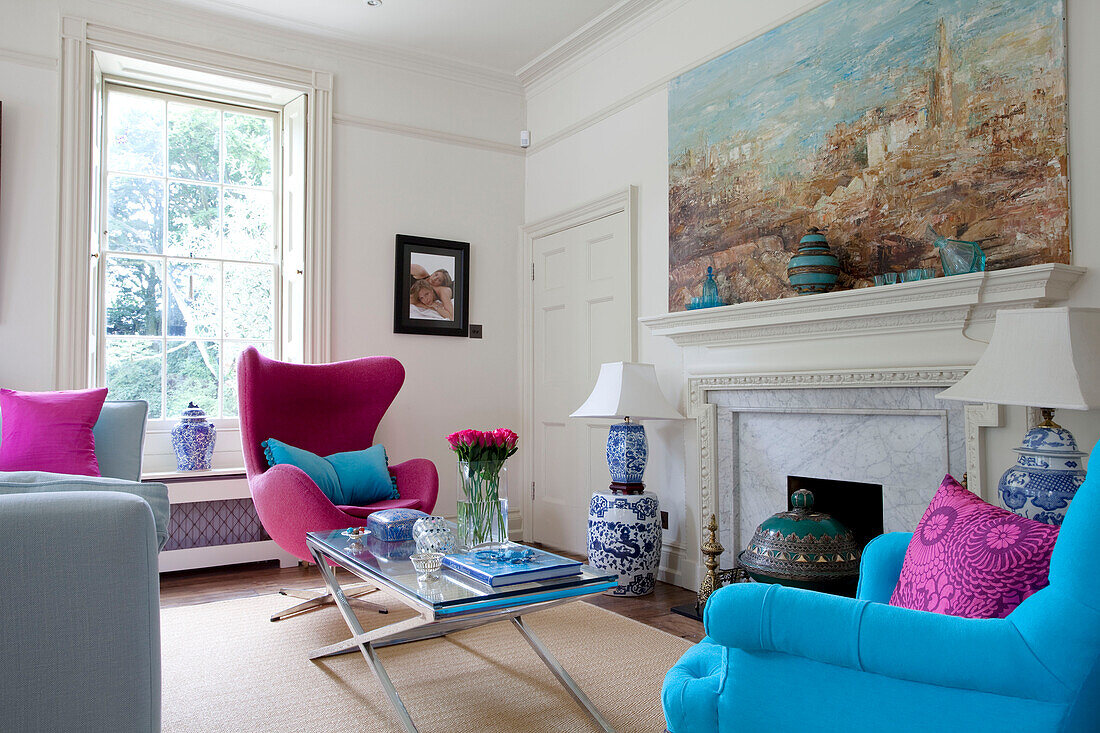 Farbenfrohe Möbel im Wohnzimmer mit großem Fenster und Kamin