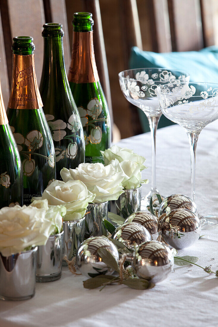 White roses and champagne bottles on table of Cotswolds home UK