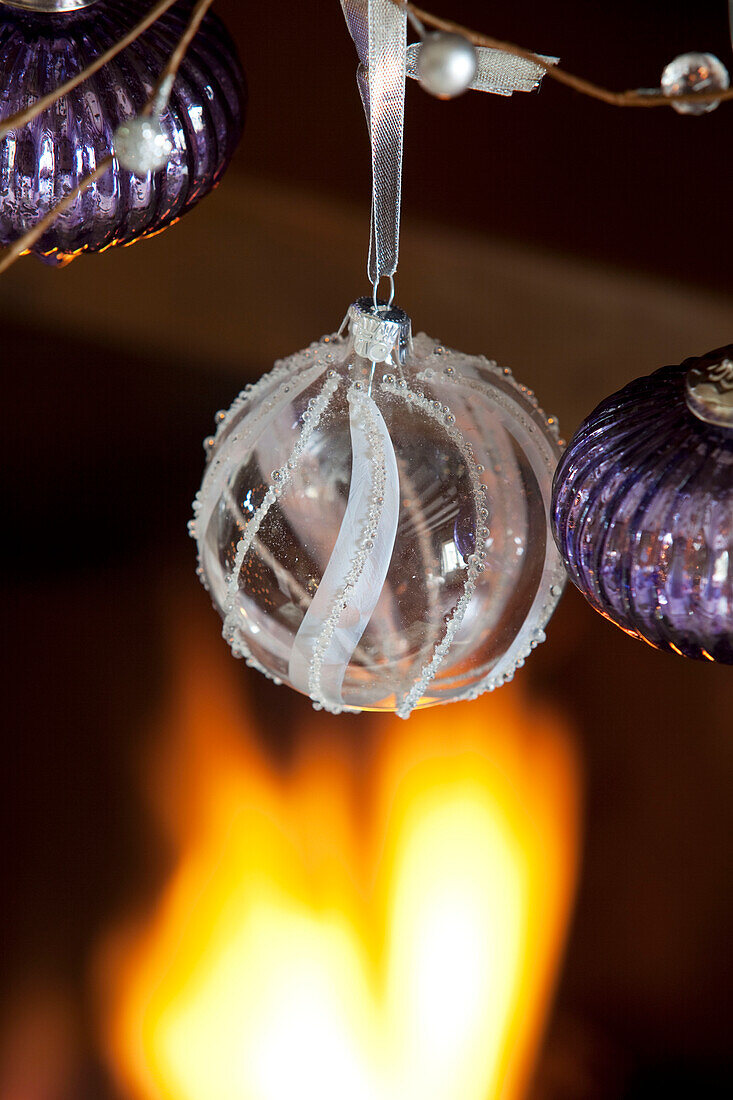 Three baubles hang at fireside in Cotswolds home UK