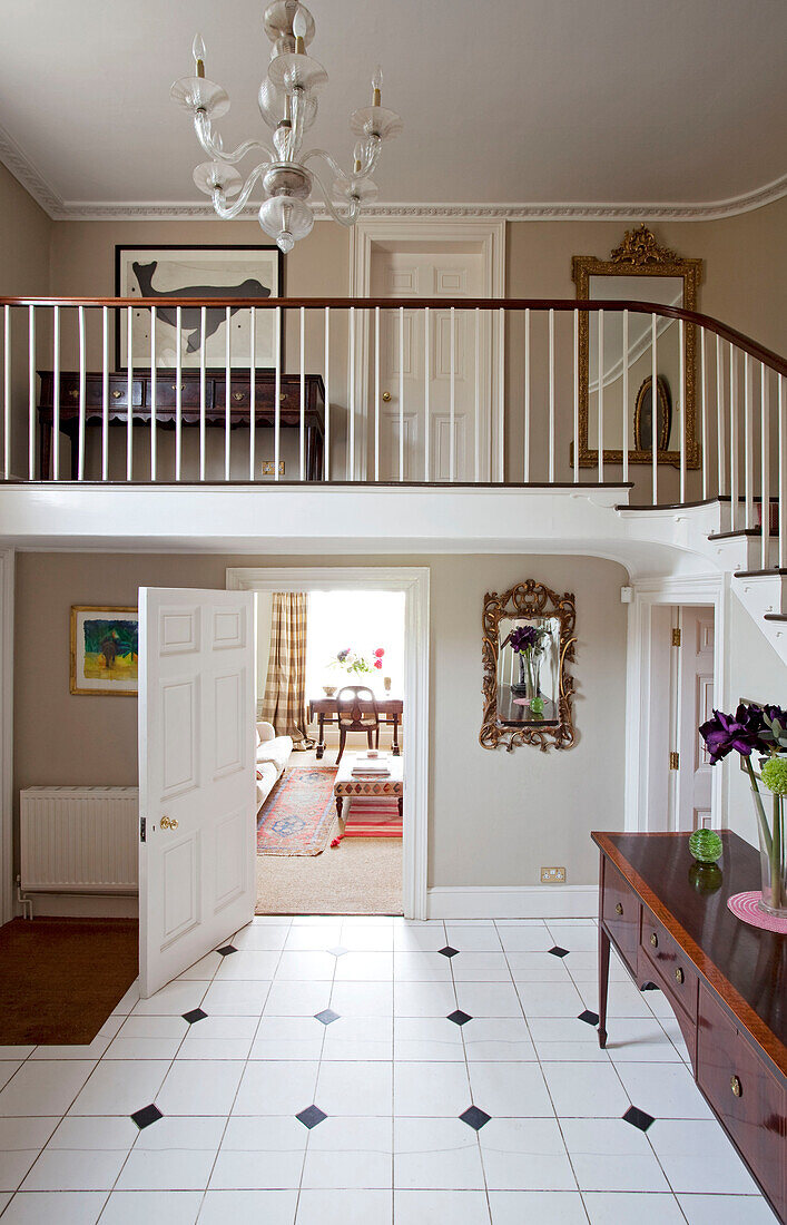 Gefliester Eingangsflur mit doppelt hoher Treppe in einem Haus in East Sussex, England, UK