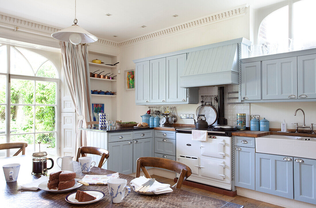 Light blue fitted units in kitchen with chocolate on table, East Sussex home, England, UK