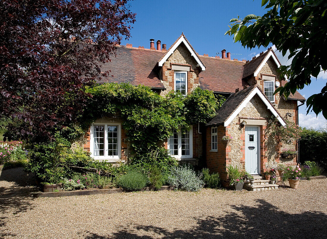 Schattige Kiesauffahrt aus Ziegeln und Stein in einem Landhaus in Kent, Großbritannien