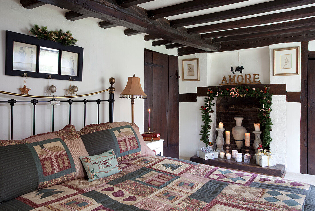 Patchwork quilt on bed in timber framed Sussex home UK