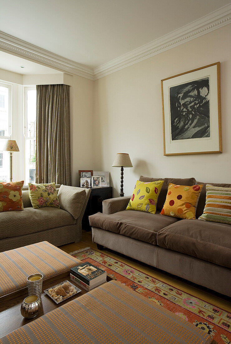 Kunstwerk über dem Sofa mit hellen Kissen in einem Haus in London, UK