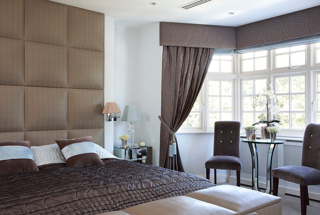 Braune gesteppte Bettdecke und Seidenkopfteil im Schlafzimmer eines Hauses in Hendon, London, Vereinigtes Königreich