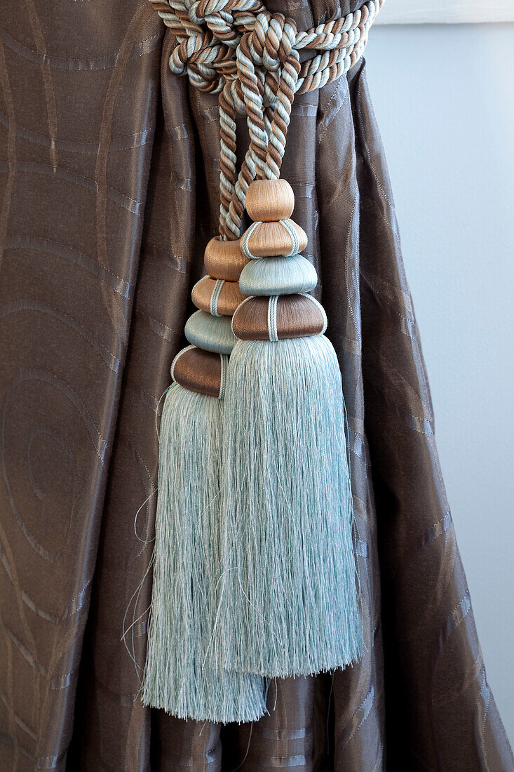 Turquoise and brown tassels tie back curtains in Hendon home London UK