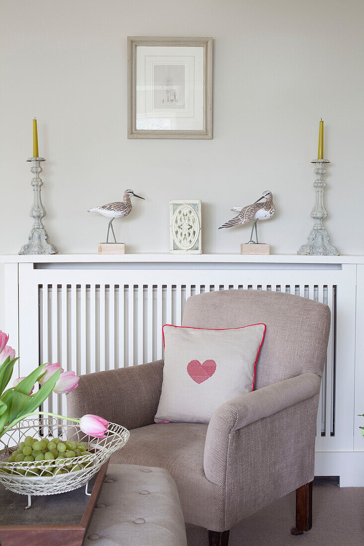 Herzförmiges Kissen auf einem Sessel am Heizkörper in einem Haus in Sussex UK