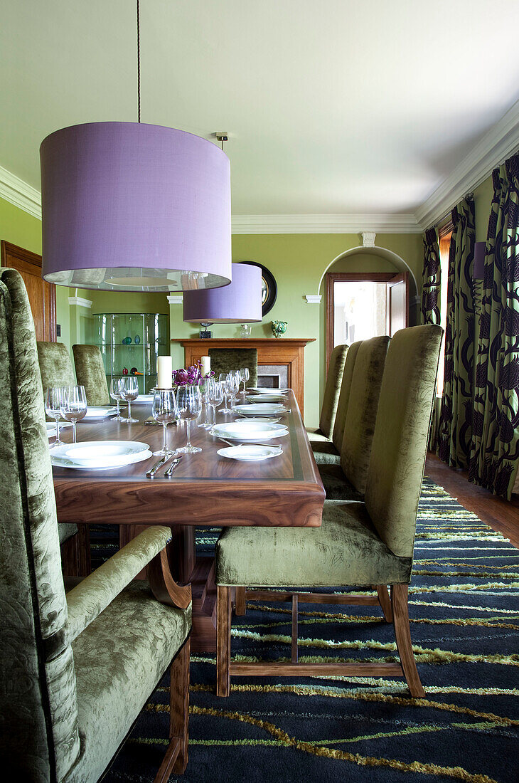 Esstisch und Stühle aus Holz mit übergroßem fliederfarbenem Lampenschirm in einem Haus in Suffolk England