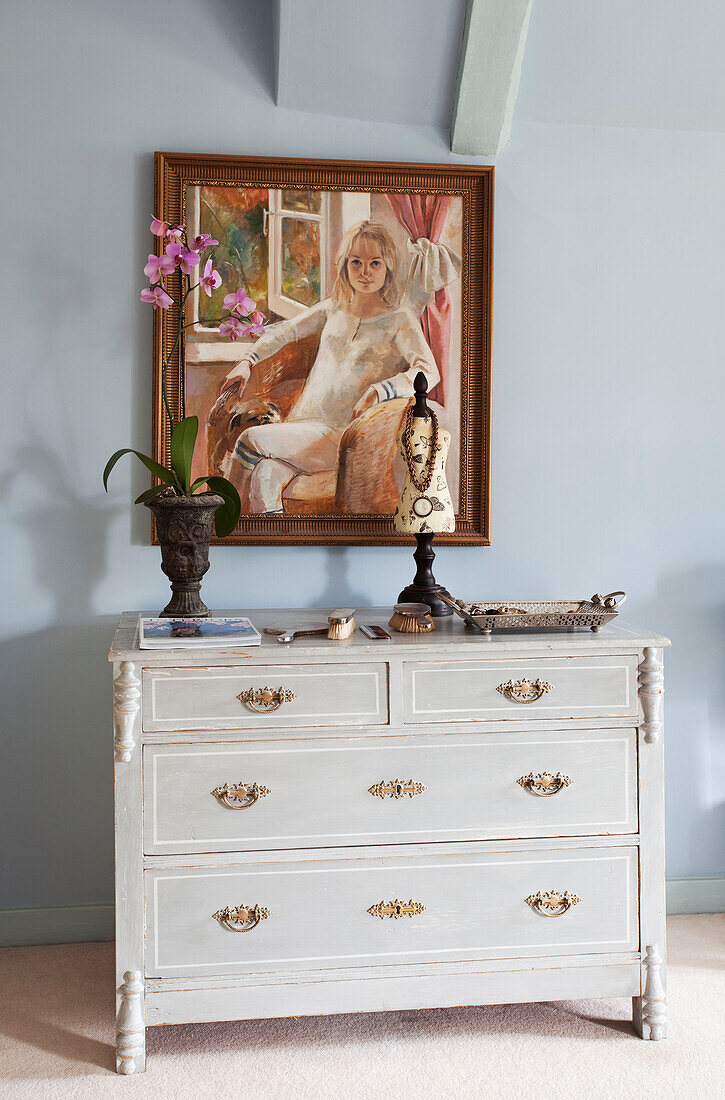 Oil painting above chest of drawers with ornaments in Sussex farmhouse, UK