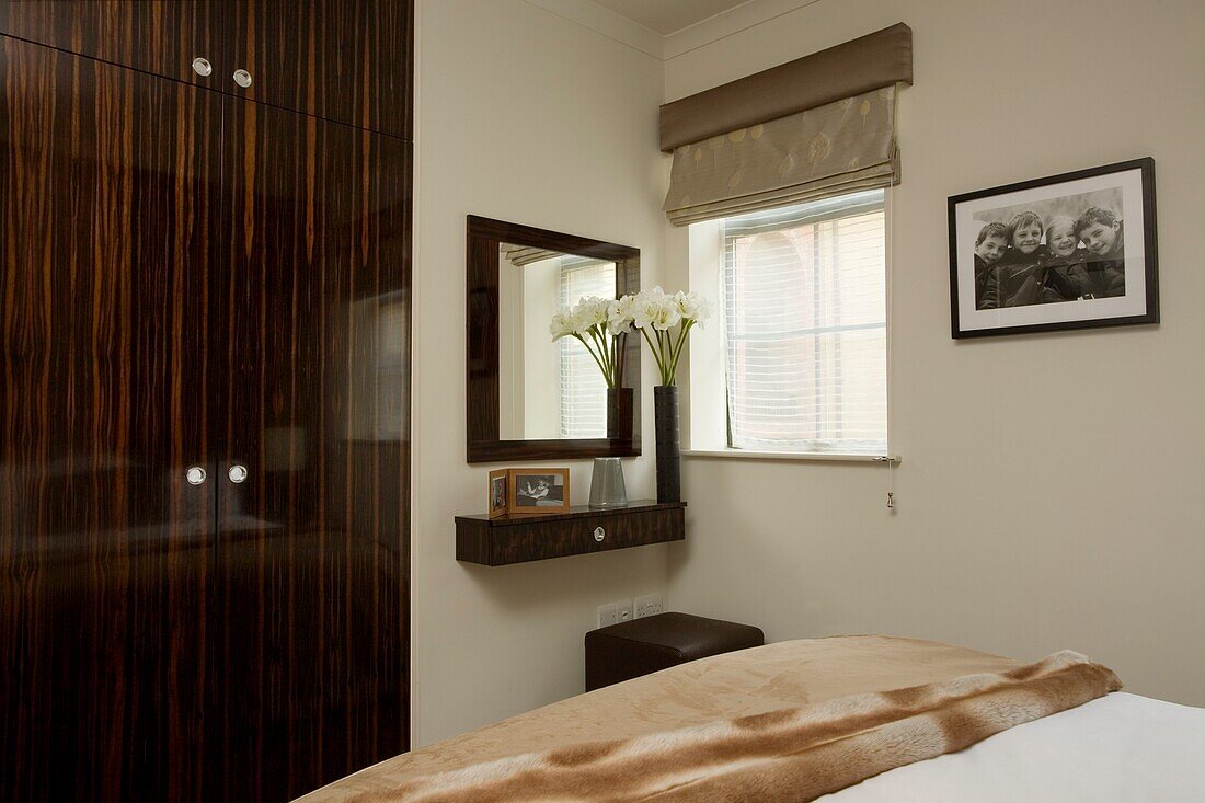 Dark wooden polished wardrobe in bedroom of contemporary Somerset home, England, UK