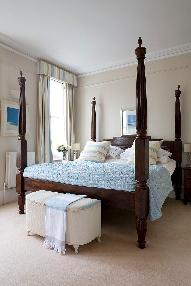 Bett mit vier Plakaten aus dunklem Holz in einem Haus in London UK