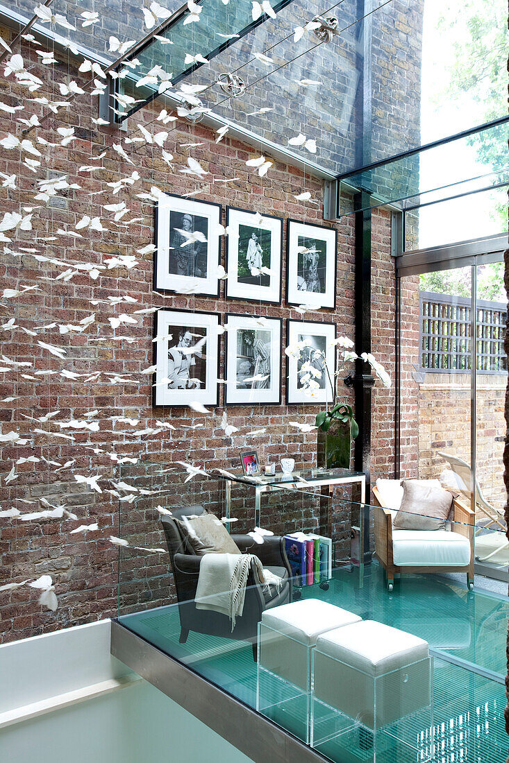 Hauserweiterung mit Ziegelwand und Glasdecke und -böden in einem modernen Londoner Stadthaus, UK