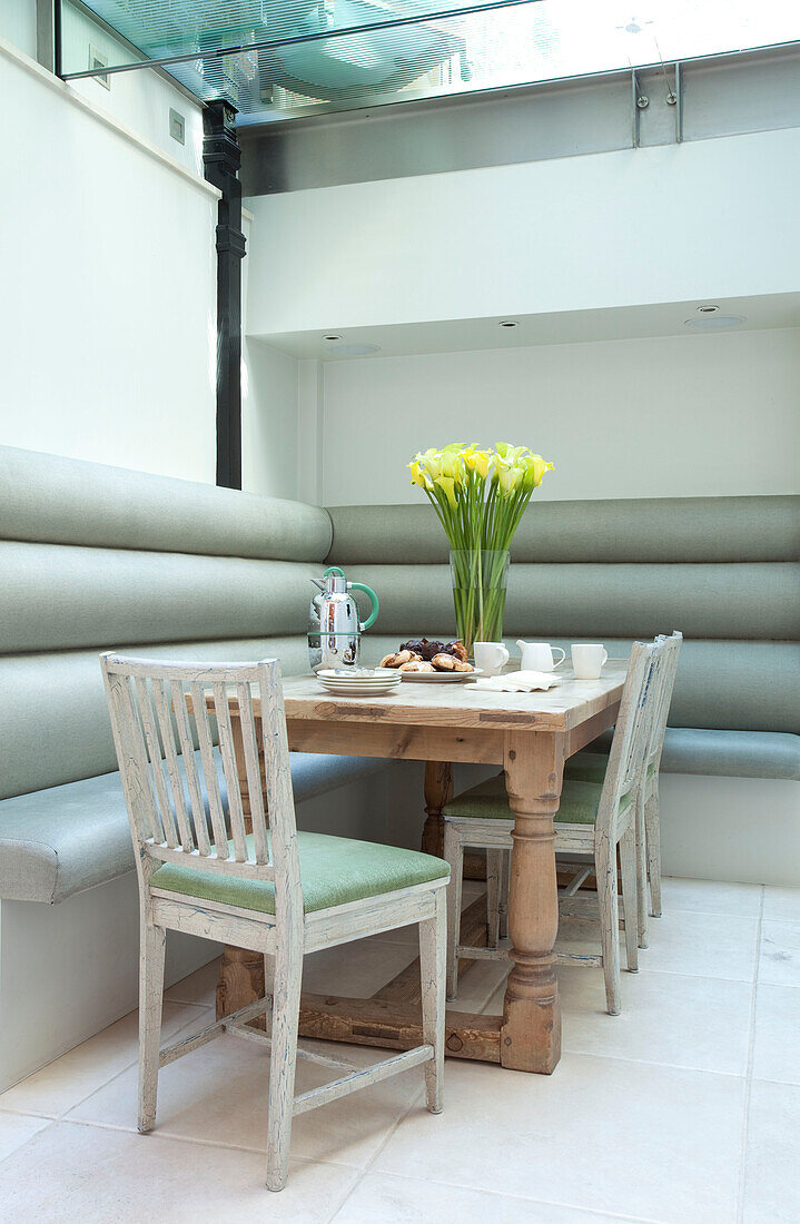 Holztisch mit Sitzbank und Stühlen im Keller eines modernen Londoner Stadthauses, UK