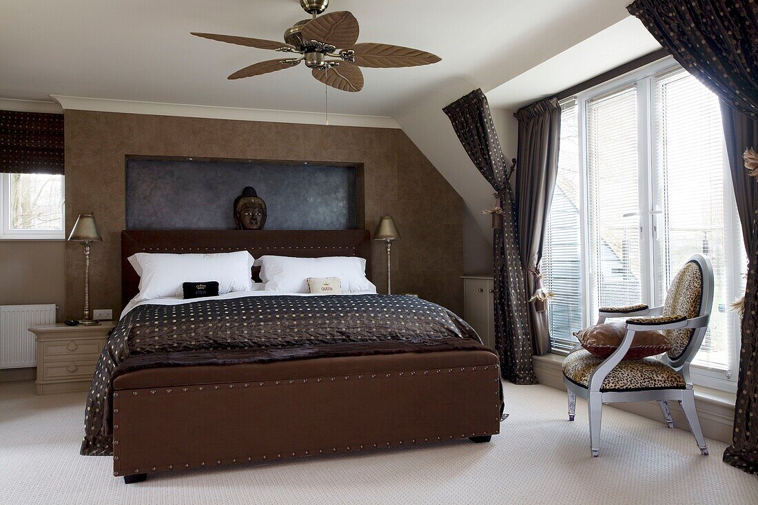 Braunes Bett in einem Zimmer mit Deckenventilator in einem modernen Londoner Stadthaus, UK