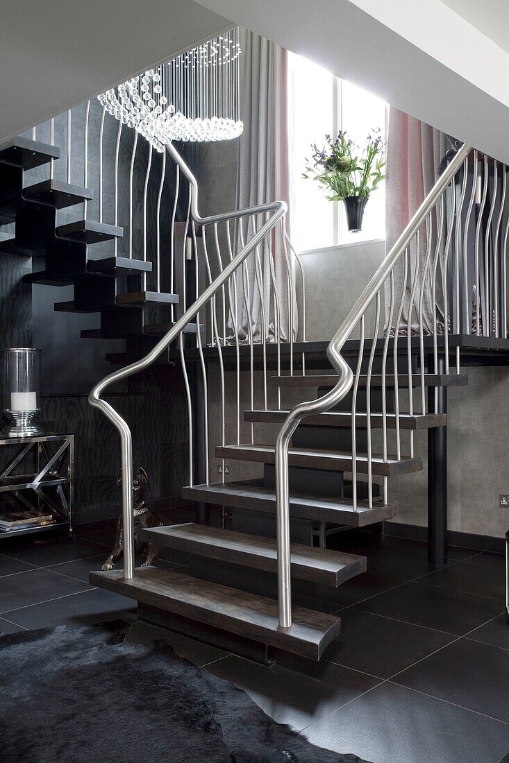 Metallhandlauf auf offener Treppe in modernem Londoner Stadthaus, UK