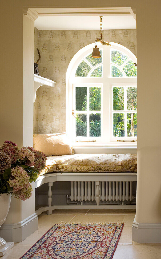 Sunlit window seat at arched window in Surrey home UK