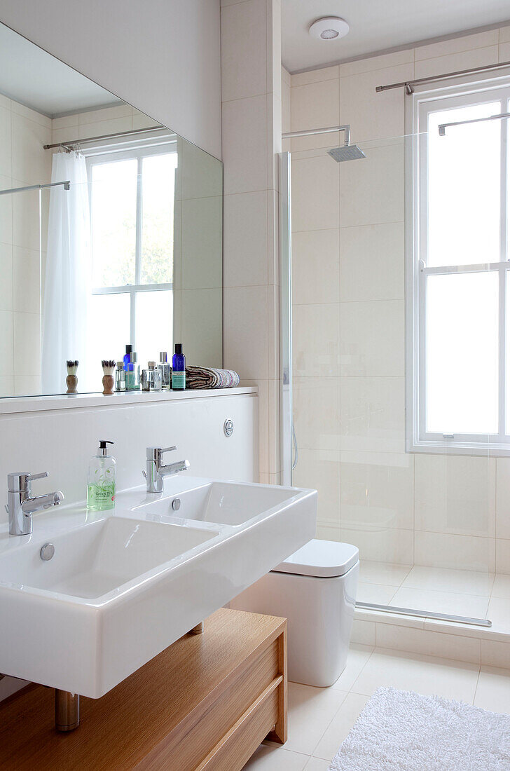 Doppelwaschbecken und Duschkabine mit großem Spiegel in einem modernen Haus, Hove, East Sussex, England, UK