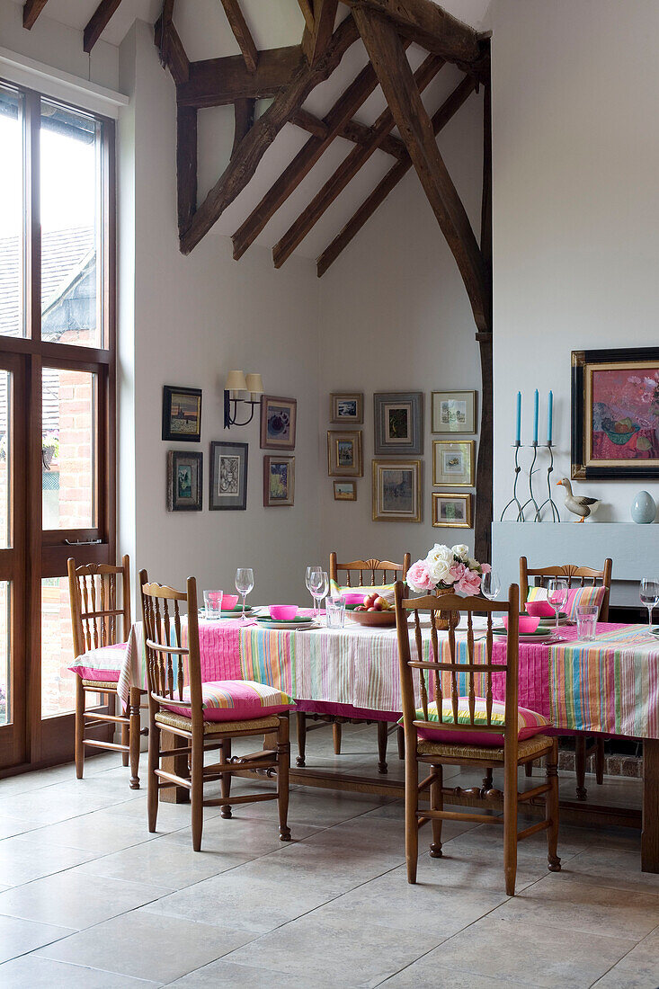 Kunstwerk über dem Kamin im Esszimmer in Sussex mit rosa gestreifter Tischdecke