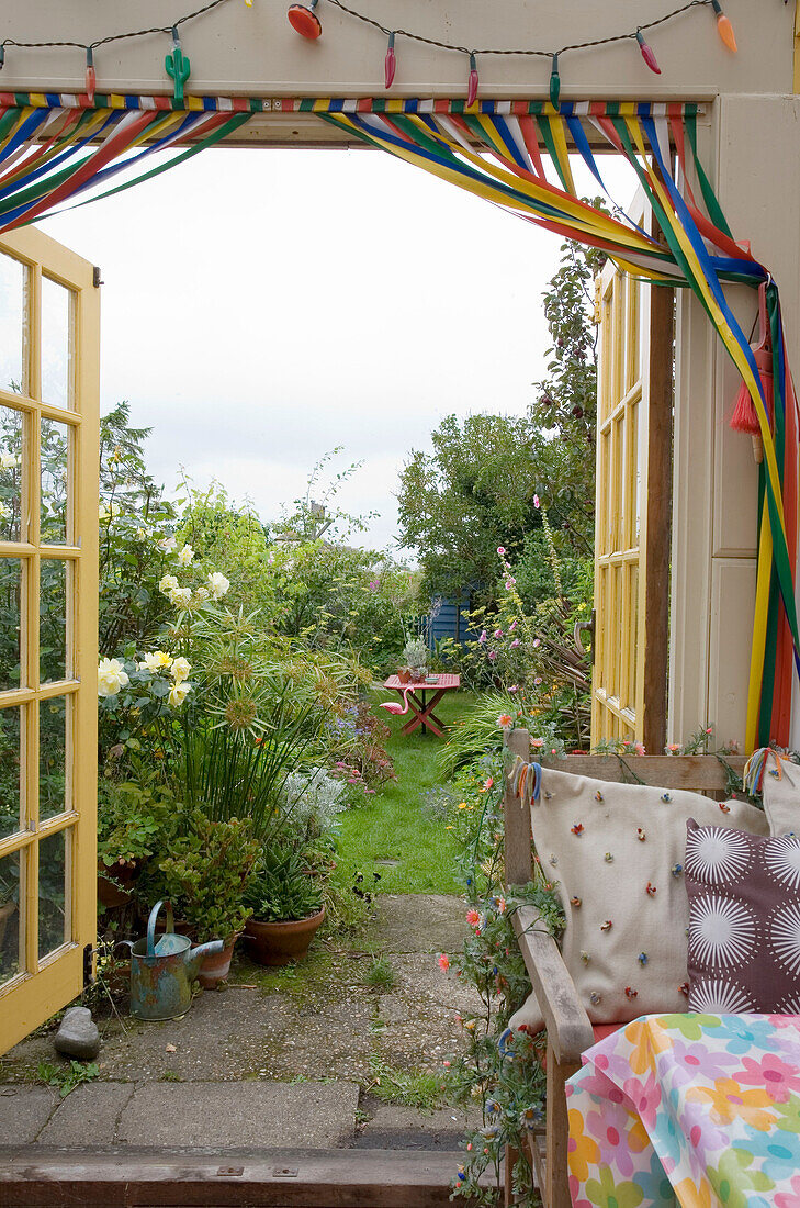 Blick durch offene Flügeltüren in den Garten des Hauses in Rye, East Sussex, England, UK