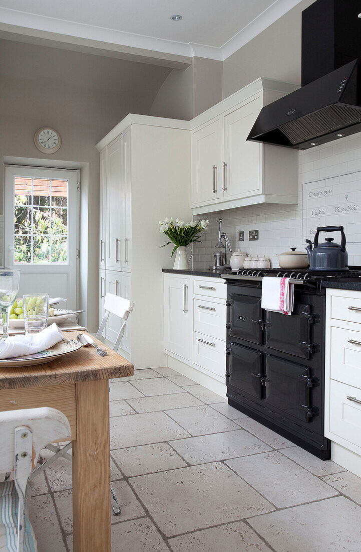 Weiße Einbaugeräte und schwarzer Herd in der Küche eines Hauses in Surrey, England, UK