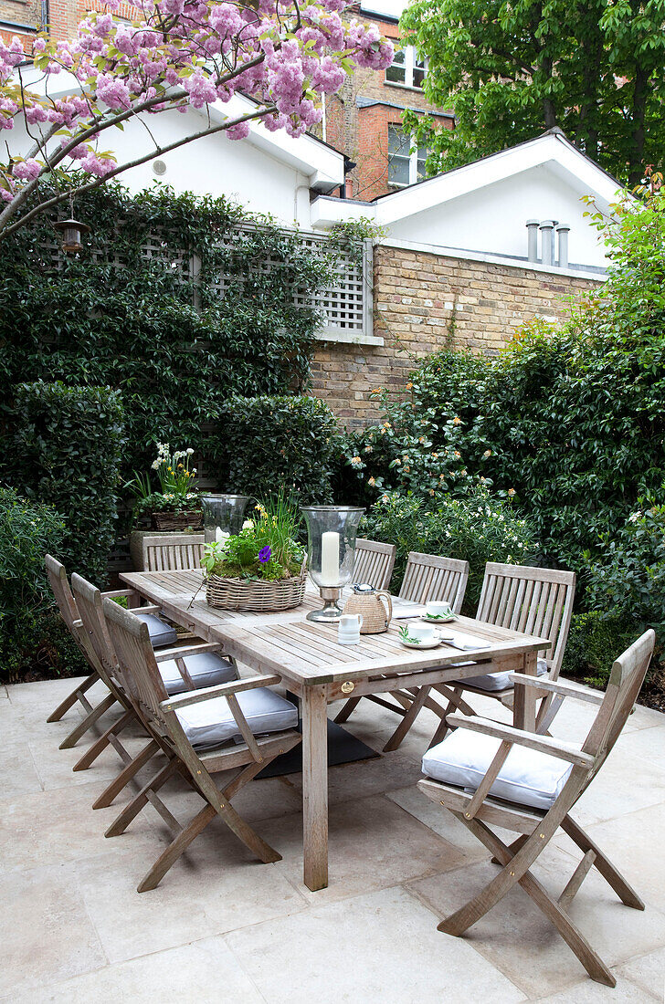 Terrassentisch und Stühle im Innenhofgarten eines modernen Londoner Stadthauses, England, UK