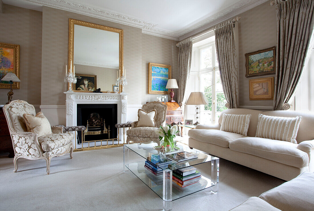 Matching armchairs at fireplace in drawing room of contemporary London townhouse, England, UK